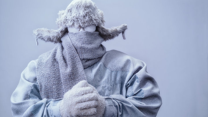 Человек в парке, шляпе и шарфе, замороженных от холода