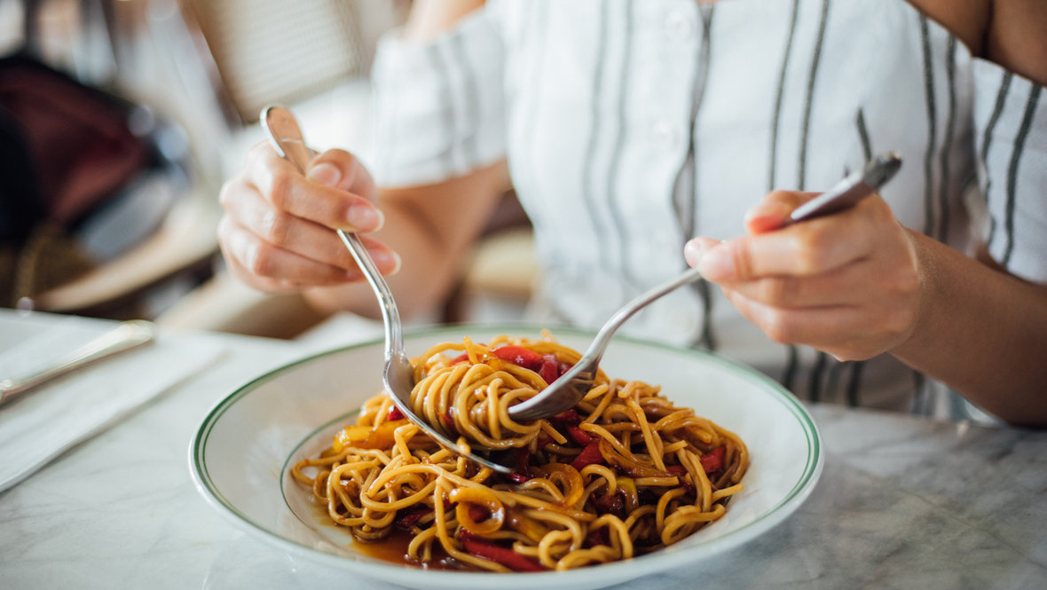 Девушка ест пасту