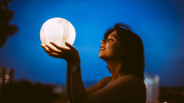 Девушка держит Луну руками