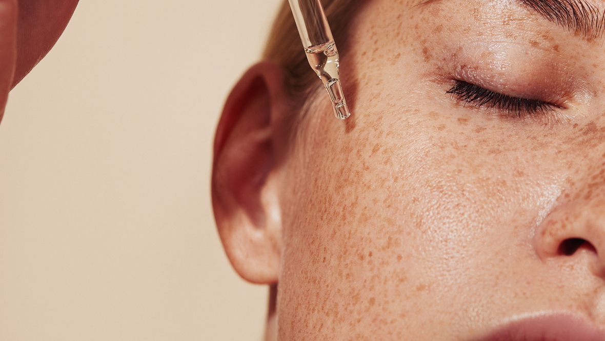 Девушка наносит сыворотку для лица