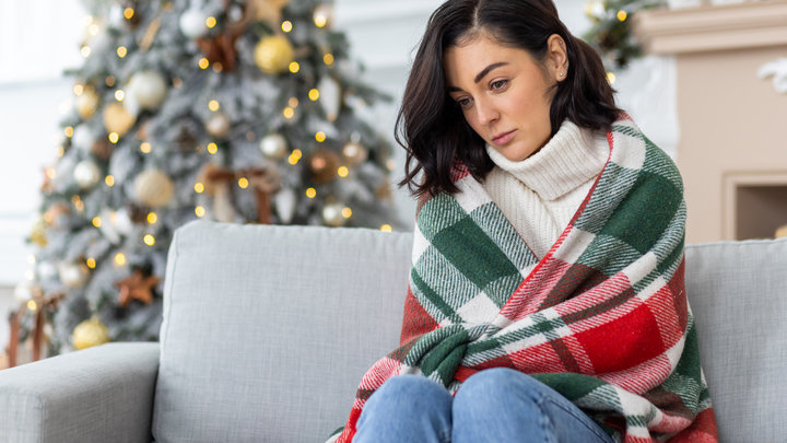 Грустная женщина сидит одна в праздники