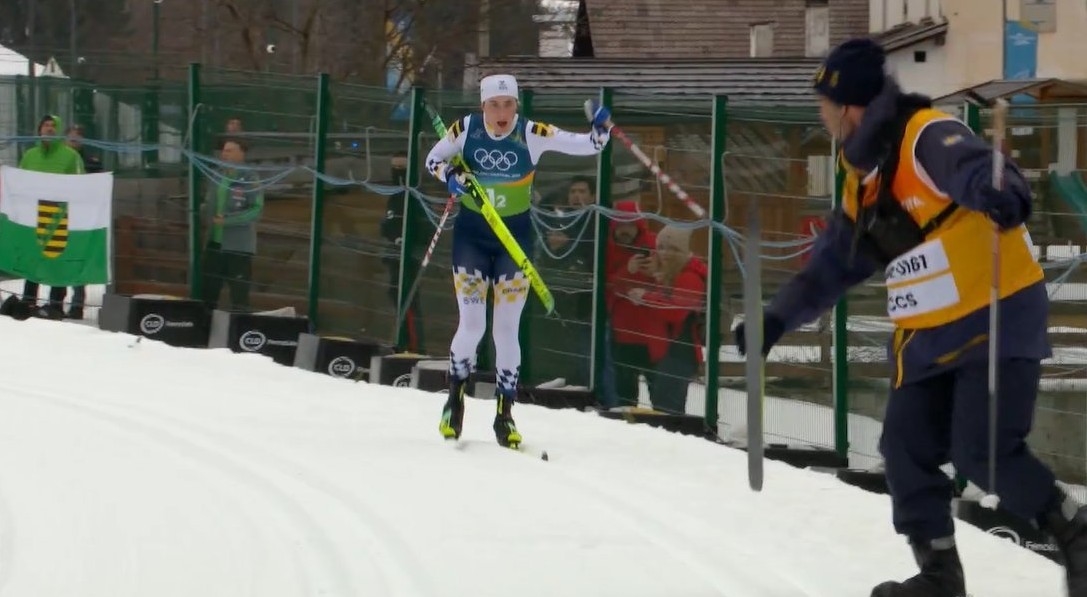 Член штаба передает Андерссон новую лыжу.