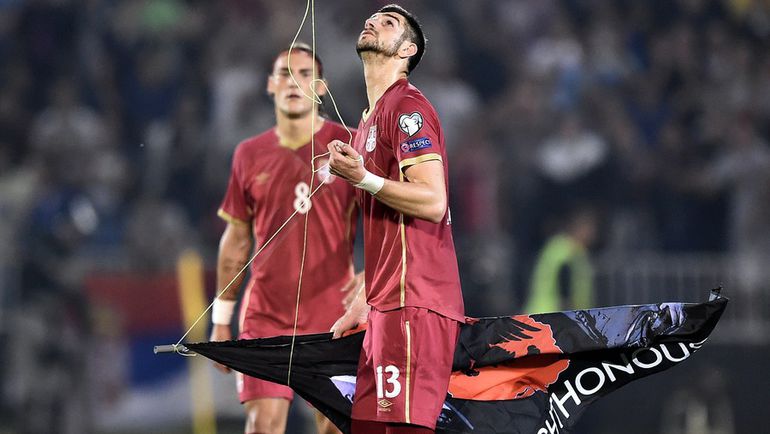 14 октября 2014 года. Белград. Защитник сборной Сербии Стефан МИТРОВИЧ с флагом, сорванным с беспилотника. Фото AFP 14 октября 2014 года. Белград. Защитник сборной Сербии Стефан МИТРОВИЧ с флагом, сорванным с беспилотника. Фото AFP