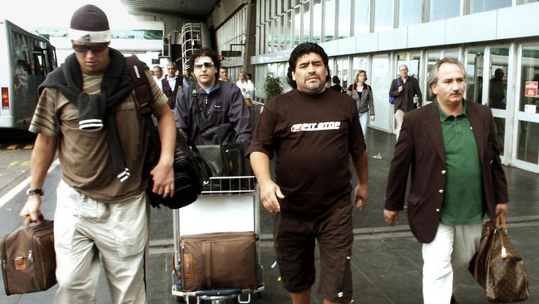 21 мая 2003 года. Рим. Диего МАРАДОНА (второй справа) направляется в аэропорт, чтобы отправиться на Кубу. Днем ранее он впервые в жизни увиделся со своим сыном от Кристины Сингары на поле для гольфа. Сначала Марадона хотел убежать от него, думая, что это охотник за автографами, однако, когда его сын представился, они стали общаться. Фото AFP 21 мая 2003 года. Рим. Диего МАРАДОНА (второй справа) направляется в аэропорт, чтобы отправиться на Кубу. Днем ранее он впервые в жизни увиделся со своим сыном от Кристины Сингары на поле для гольфа. Сначала Марадона хотел убежать от него, думая, что это охотник за автографами, однако, когда его сын представился, они стали общаться. Фото AFP