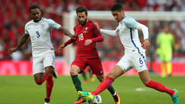 Хавбек сборной Португалии РАФА СИЛВА против защитников англичан Криса СМОЛЛИНГА и Дэнни РОУЗА (№ 3).