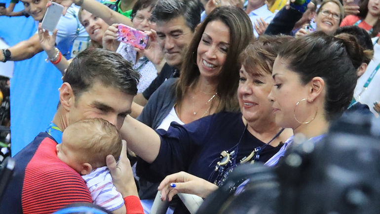 Вторник. Рио-де-Жанейро. Майкл ФЕЛПС целует сына Бумера после церемонии награждения на дистанции 200 метров баттерфляем. Фото AFP Вторник. Рио-де-Жанейро. Майкл ФЕЛПС целует сына Бумера после церемонии награждения на дистанции 200 метров баттерфляем. Фото AFP