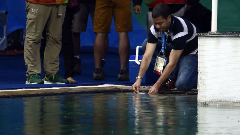 Специалисты производят забор воды из бассейна. Фото AFP Специалисты производят забор воды из бассейна. Фото AFP