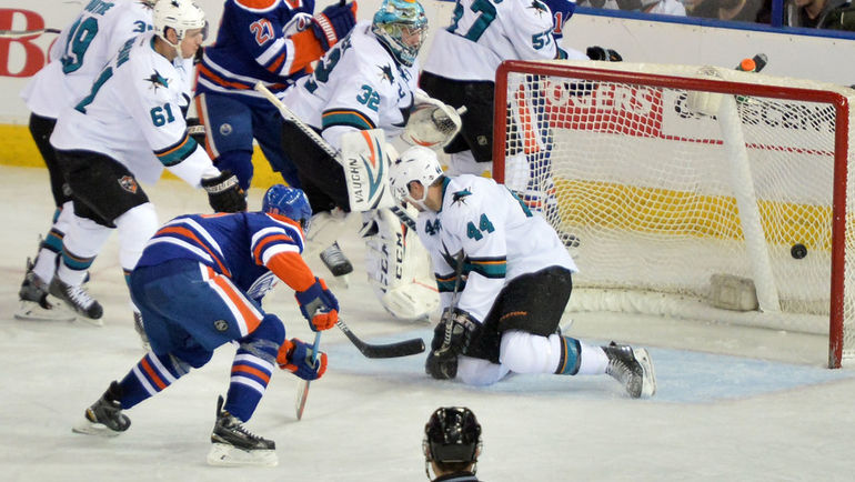 Наиль ЯКУПОВ забрасывает шайбу в ворота, которые пытается заблокировать Марк-Эдуард ВЛАСИК.